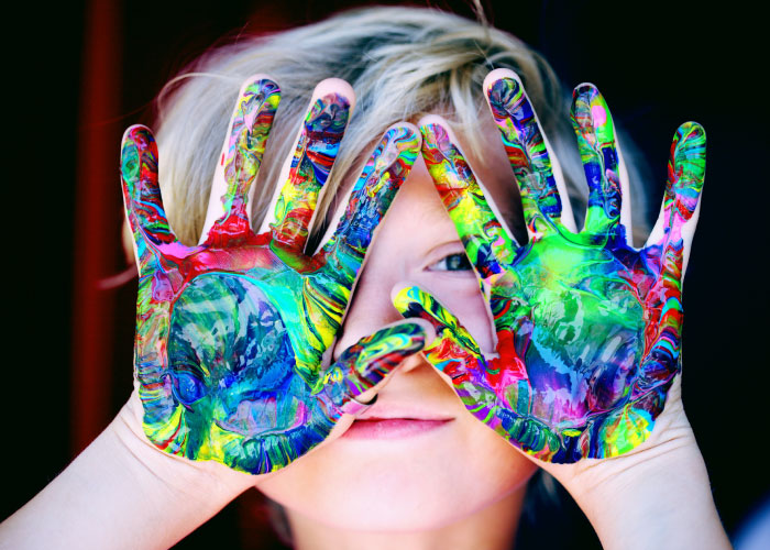 Child with paint on their hands.
